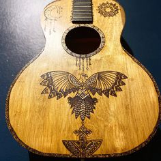 a wooden guitar with an intricate design on it