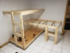 a wooden workbench sitting on top of a white tiled floor