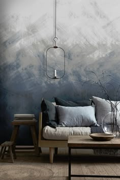 a living room with a couch, coffee table and lamp hanging from the ceiling over it