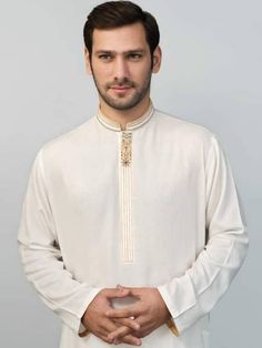 <ul> <li>Color: Off-White</li> <li>Handsome kurta features embellishments and embroidery on palcket and collar</li> <li>Complemented with matching shalwar</li> </ul> <p><br /><br /><strong>Additional Accessories:</strong><br />Peshawari Sandal: <strong>US$50</strong><br />Men's Shawl: <strong>US$50</strong></p> Elegant White Lawn Suit With Embroidered Border, Elegant Lawn Suit With Embroidered Border For Wedding, Long Sleeve Lawn Suit With Embroidered Border For Wedding, Long Sleeve Embroidered Lawn Suit For Wedding, White Sherwani With Embroidered Border For Transitional Season, Transitional White Sherwani With Embroidered Border, Formal Embroidered Lawn Suit For Transitional Season, Formal Gold Embroidered Lawn Suit, White Long Sleeve Lawn Suit With Embroidered Border