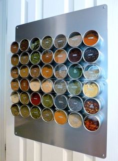 a metal wall mounted spice rack filled with lots of different types of spices and seasonings