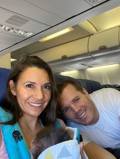 two people and a baby on an airplane