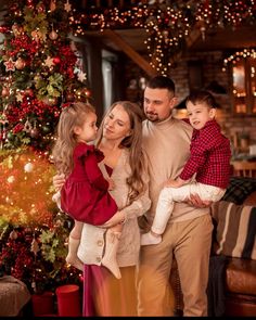 a family standing in front of a christmas tree