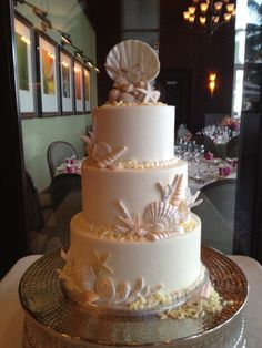 a three tiered cake with seashells on it