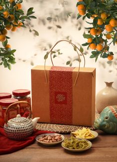 an orange tree is in the background with some food on plates and a paper bag