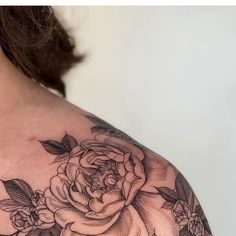 a woman's shoulder with a rose tattoo on her left arm and the upper half of her body