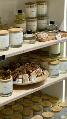 shelves filled with jars and candles on top of each other