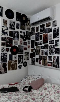 a bed in a room with lots of pictures on the wall