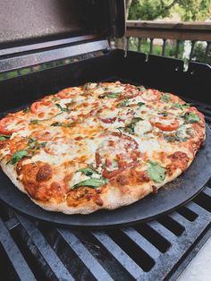 a large pizza sitting on top of a grill