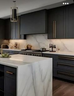 a kitchen with marble counter tops and black cabinets