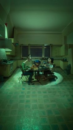 two people sitting at a table in the middle of a room with green lights on