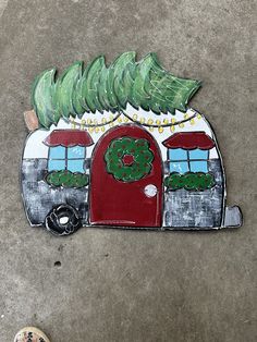 a painting of a camper with a christmas wreath on it's front door