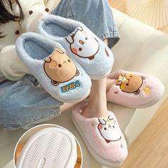 women's slippers with cartoon animals on the bottom and side, sitting on a couch