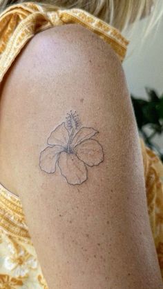 a woman with a flower tattoo on her arm