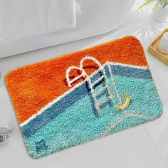 a bathroom rug with an image of a ladder on the beach and a heart shaped bow