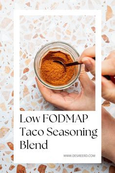 a person holding a spoon in a jar filled with taco seasoning and the text low fodmap taco seasoning blend