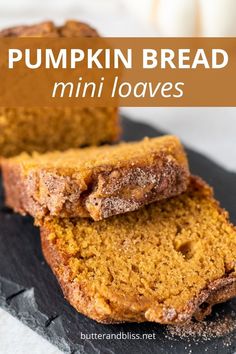 two slices of pumpkin bread sitting on top of a black slate platter with the words, pumpkin bread mini loaves