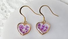 Dainty and elegant, handmade dangle earrings, made with real dried pressed flowers and eco-friendly resin. Made with... -Real Queen Annes Lace flowers, Purple -18K Gold Plated Stainless-steel Fish hooks, Hypoallergic -Eco-friendly resin, that is resistant to scratches, water, and UV rays, so it won't turn yellow. -Features a beautiful crystal clear domed finish-Flower Meanings- -Queen Annes Lace- A symbol of catching dreams, and of sanctuary, purity, protection, and good health. Another meaning Queen Anne's Lace Flowers, Pressed Flower Earrings, Gold Heart Earrings, Dried Pressed Flowers, Handmade Dangle Earrings, Gold Heart Earring, Flower Meanings, Dried And Pressed Flowers, Flowers Purple