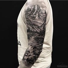 a man's arm with mountains and water on it