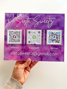 a person holding up a purple business card with qr code on it