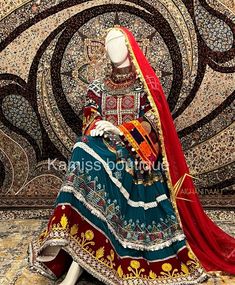 a mannequin dressed in an elaborately designed outfit with red and gold accents