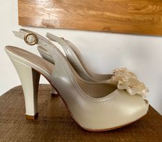 "A gracefully flower accented bridal sandal. Indulge in decadence with this stunning platform peep toe pump. Bridal style. Pearlized Leather.  Leather upper, insole, lining and leather sole. Double pad for extra comfort. Heel 6\". 1\" platform. Not only will you have the most beautiful shoes, but you will feel like you're walking on clouds! Peep toe pump  Pearlized Leather upper Satin flower accent Leather insole Leather lining Leather sole Platform style highly comfortable.  Double pad for extra comfort. Light weight Return Policy: We accept returns within 15 days. Shoes must be returned in new condition in the original box and packaging. No damage shoes or box is accepted back.No refunds on shipping costs. Buyer pay returns. There is a 15% fee for restocking the item. No fees for exchang Cream Open Toe Wedding Shoes For Gala, Elegant Platform Wedding Shoes, Elegant Platform Wedding Heels, Cream Open Toe Heels For Ceremonies, Beige Open Heel Wedding Heels, Elegant Cream Heels For Ceremony, Cream Platform Heels For Wedding, Cream Open Toe Heels For Wedding Guest, Cream Open Toe Shoes For Wedding Guest