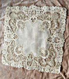 an old lace doily is laying on a bed