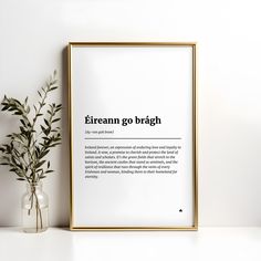 there is a vase with some plants in it next to a framed poster that says, eireann go brach