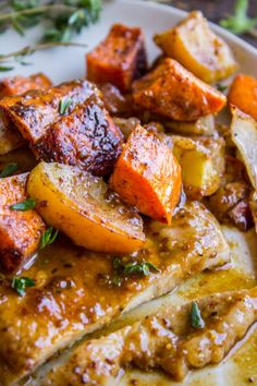 a white plate topped with chicken, potatoes and carrots