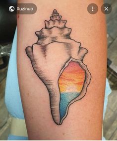 a small tattoo on the arm of a woman with a colorful sea shell in it