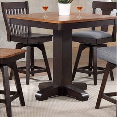 a dining room table with chairs and a potted plant on the counter top in front of it