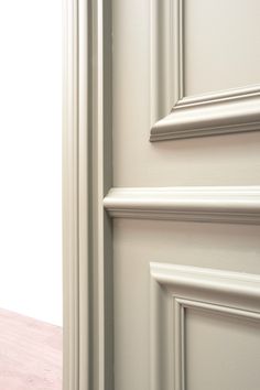 an open door with white trim and wood flooring next to it on a wall