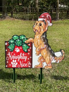 a sign with a dog holding a present in it's paws and wearing a santa hat