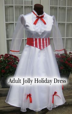 a white dress with red bows on the waist and sleeves is displayed in front of a window