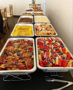 many trays of food are lined up on a table