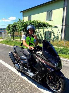 a man riding on the back of a black motorcycle