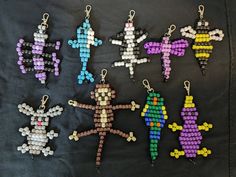 six beaded keychains are arranged on a black cloth