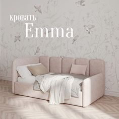 a bed sitting on top of a wooden floor in front of a wall with flowers