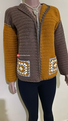 a mannequin wearing a brown and yellow jacket with white squares on it's chest