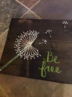 a wooden sign that says be free with a dandelion in the center and words written on it