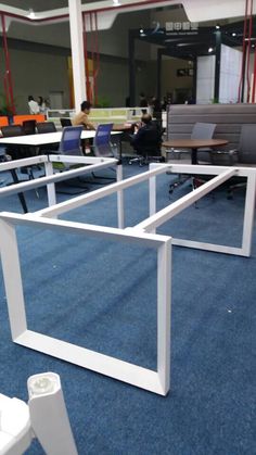 an office building with tables and chairs in the middle of blue carpeted flooring