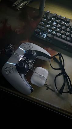 a pair of glasses sitting on top of a desk next to a remote control and keyboard