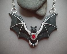 This cute black bat is flying in the sky and carrying the crescent Moon in her paws. The necklace is hand-sculpted of polymer clay and decorated with fancy filigree, glossy enamels and shiny lab created ruby gem. A really statement jewelry piece to make your Halloween or Gothic outfit perfect. Bib width 4 inches. Bib height 2 1/2 inches. Necklace length 20 inches. Please feel free to contact me if you need a customization. Frickin Bats, Gothic Outfit, Flying Bat, Bat Jewelry, Bat Necklace, Elven Jewelry, Polymer Clay Bracelet, Clay Bracelet, Unusual Earrings