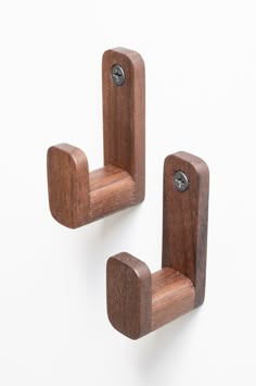 two wooden pegs are attached to each other on a white background, one has a button in the middle