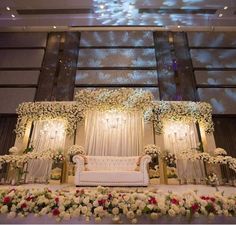 a white couch sitting under a stage covered in flowers