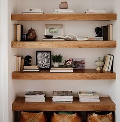 three wooden shelves filled with books and vases