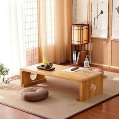 a living room with a wooden table and chair in the corner, near a window