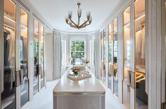 an elegant hallway with mirrored doors and chandelier