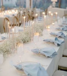 the table is set with candles, flowers and napkins for an elegant wedding reception