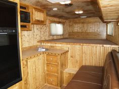 the inside of an rv with wood paneling and leather couches, cabinets, and counter tops